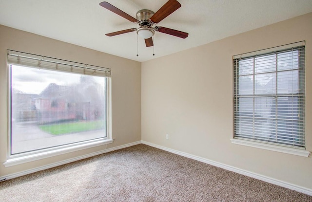 carpeted spare room with ceiling fan