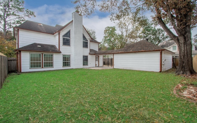 rear view of house featuring a yard