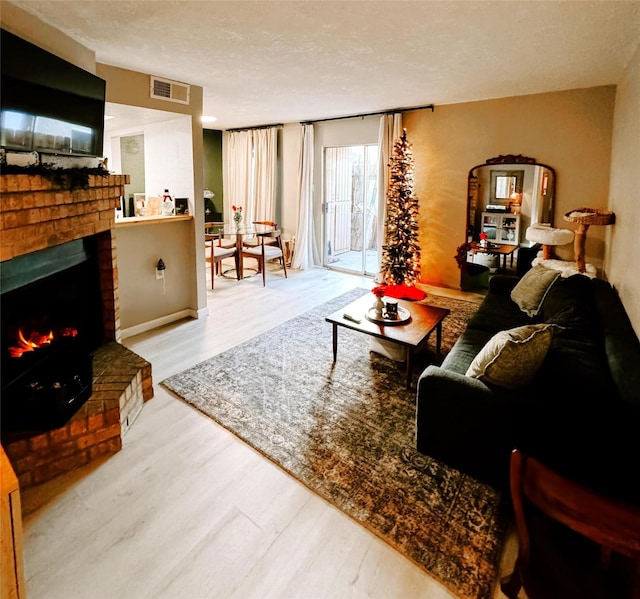 living room featuring hardwood / wood-style floors, a fireplace, and a textured ceiling