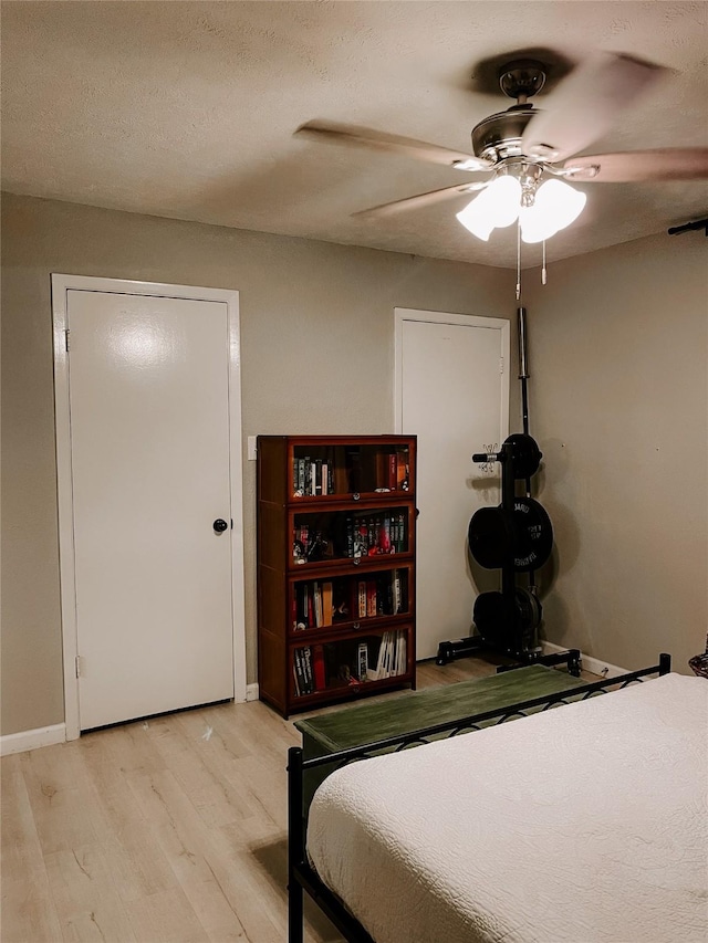 bedroom featuring a textured ceiling, light hardwood / wood-style flooring, and ceiling fan