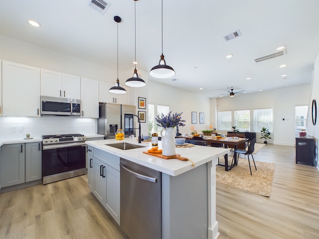 8321 Springwood Creek Ln, Houston, TX 77055 - kitchen with appliances with stainless steel finishes, a sink, gray cabinets, light countertops, and light wood-type flooring