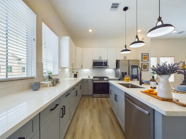 8321 Springwood Creek Ln, Houston, TX 77055 - kitchen with stainless steel appliances, a sink, gray cabinetry, plenty of natural light, and recessed lighting