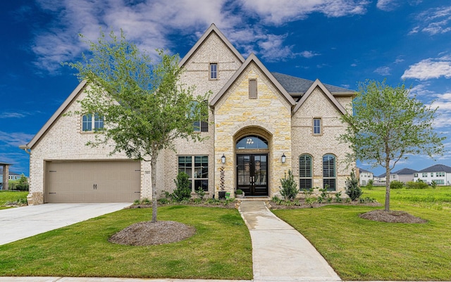 view of front facade with a garage, a front yard, and french doors