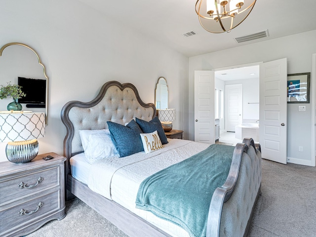 bedroom with ensuite bath, carpet floors, and a chandelier