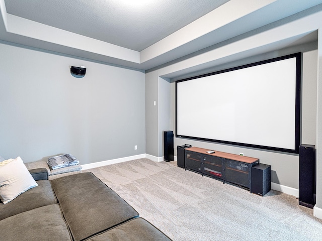 home theater room featuring light colored carpet and a textured ceiling