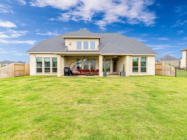 rear view of property featuring a yard, an outdoor hangout area, a patio, and ceiling fan