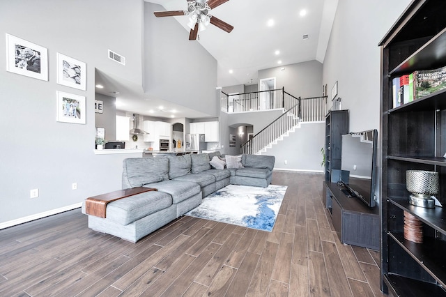 living room featuring ceiling fan, dark hardwood / wood-style flooring, and a high ceiling