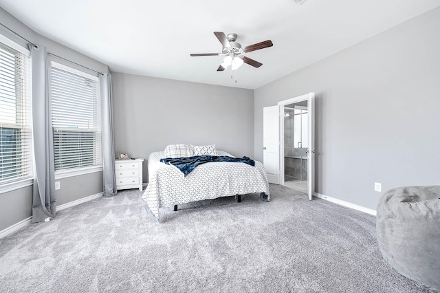 bedroom featuring light colored carpet, ceiling fan, and ensuite bathroom