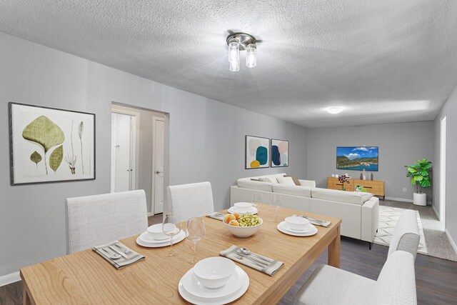 dining room with dark hardwood / wood-style floors and a textured ceiling