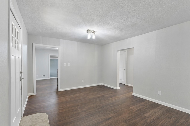 spare room with dark hardwood / wood-style flooring and a textured ceiling