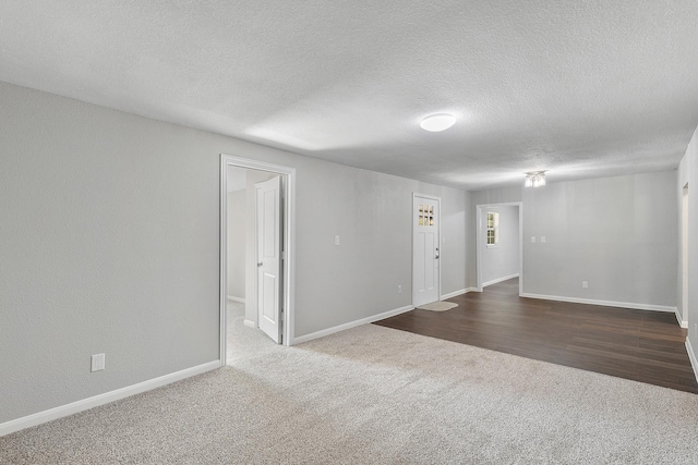 carpeted empty room with a textured ceiling