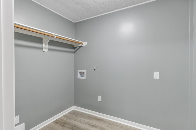 washroom featuring hookup for a washing machine, light hardwood / wood-style floors, and ornamental molding