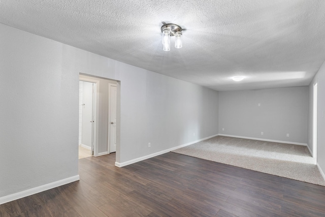 empty room featuring a textured ceiling and dark hardwood / wood-style flooring