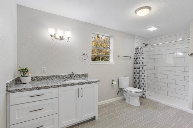 bathroom with a shower with curtain, vanity, toilet, and a textured ceiling