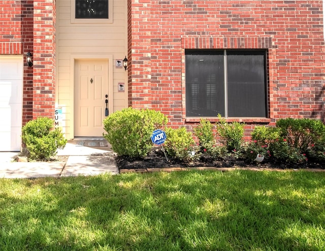 view of exterior entry featuring a yard