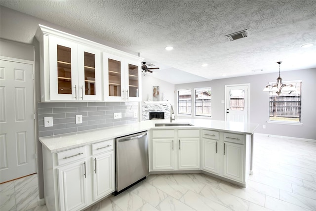 kitchen featuring decorative backsplash, dishwasher, sink, and white cabinets