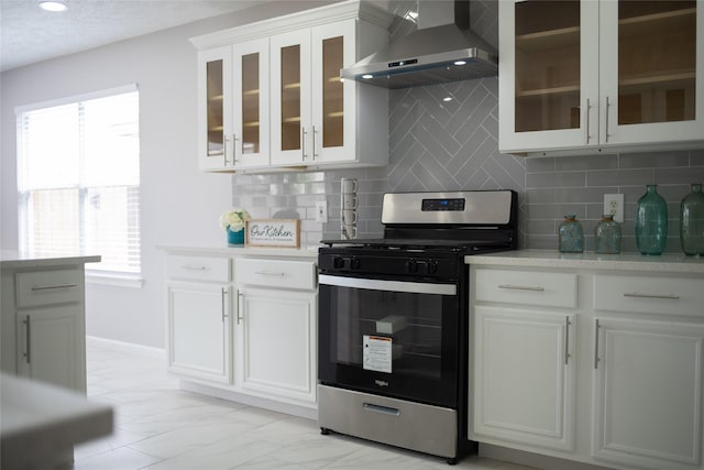 kitchen with tasteful backsplash, stainless steel range with gas cooktop, a healthy amount of sunlight, and wall chimney range hood