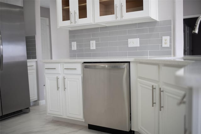 kitchen with decorative backsplash, white cabinetry, and stainless steel appliances