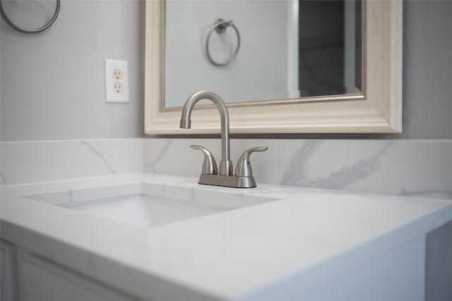 room details featuring decorative backsplash and vanity