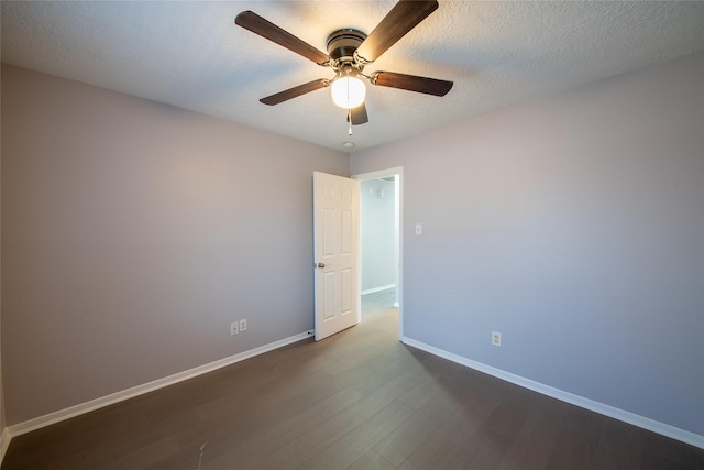 empty room with ceiling fan, dark hardwood / wood-style flooring, and a textured ceiling