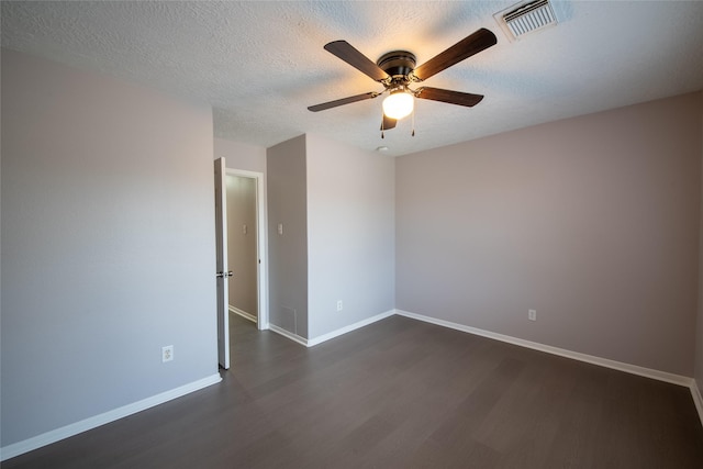 spare room featuring ceiling fan, dark hardwood / wood-style flooring, and a textured ceiling