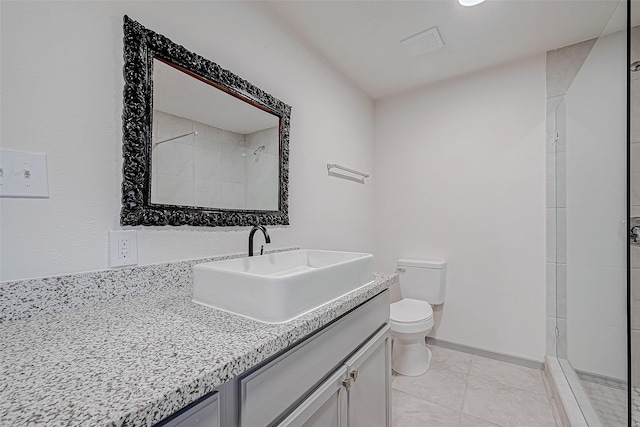 bathroom featuring tiled shower, tile patterned floors, vanity, and toilet