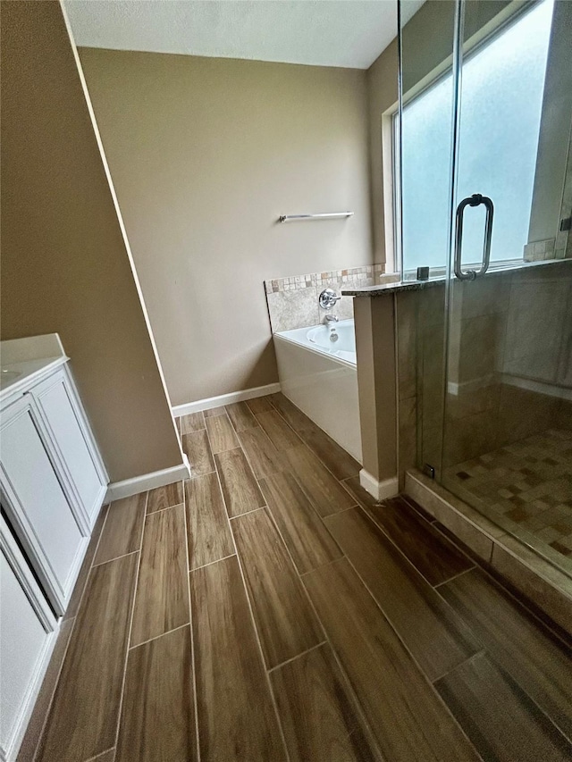 bathroom featuring separate shower and tub and vanity