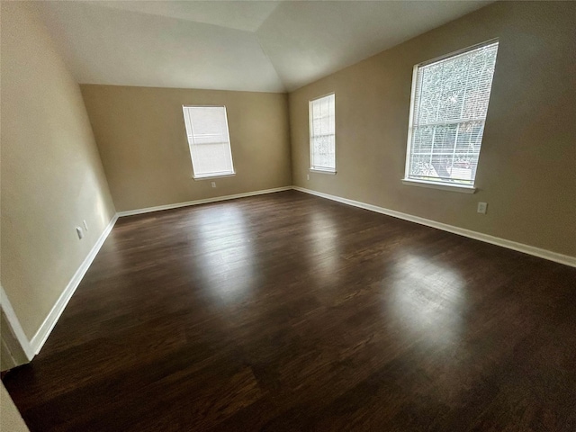 unfurnished room with dark hardwood / wood-style flooring and lofted ceiling