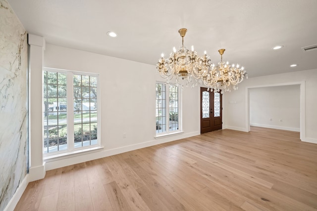 interior space featuring french doors, a chandelier, plenty of natural light, and light hardwood / wood-style floors