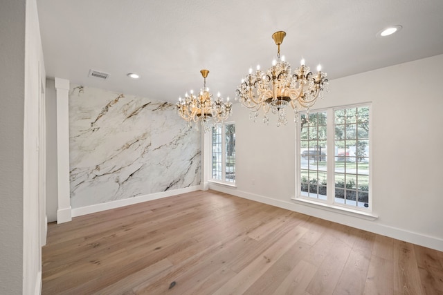 unfurnished dining area featuring hardwood / wood-style flooring and a notable chandelier