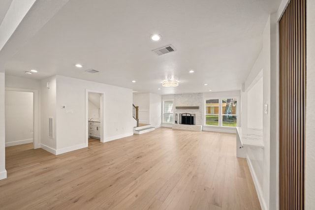 unfurnished living room with light wood-type flooring and a fireplace