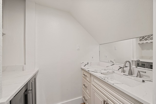 bathroom with vanity and vaulted ceiling