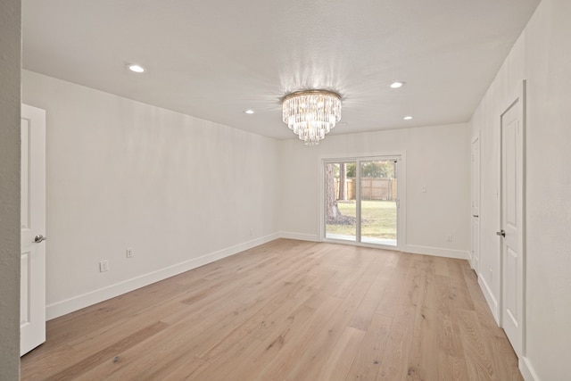 unfurnished bedroom with light hardwood / wood-style floors and a notable chandelier