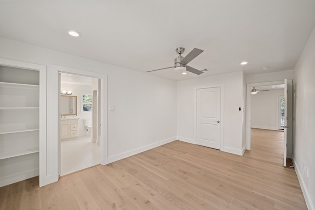 unfurnished bedroom with multiple windows, ceiling fan, light hardwood / wood-style flooring, and ensuite bathroom