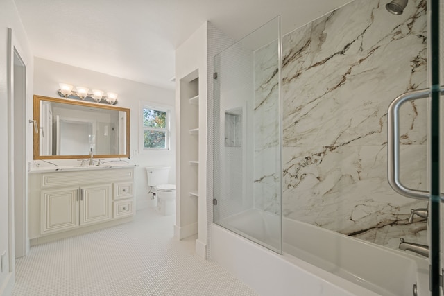 full bathroom with tile patterned floors, vanity, combined bath / shower with glass door, and toilet