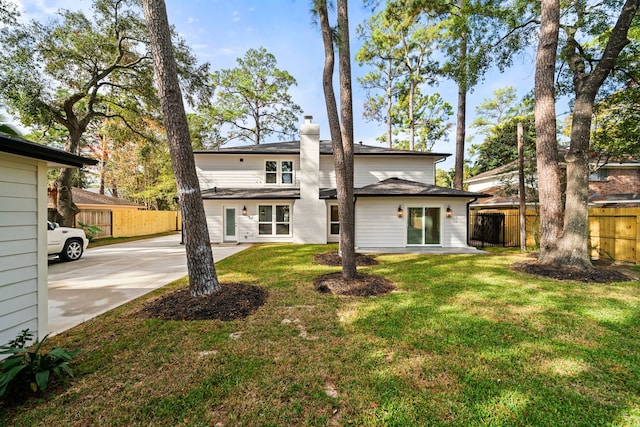 rear view of house featuring a lawn and a patio