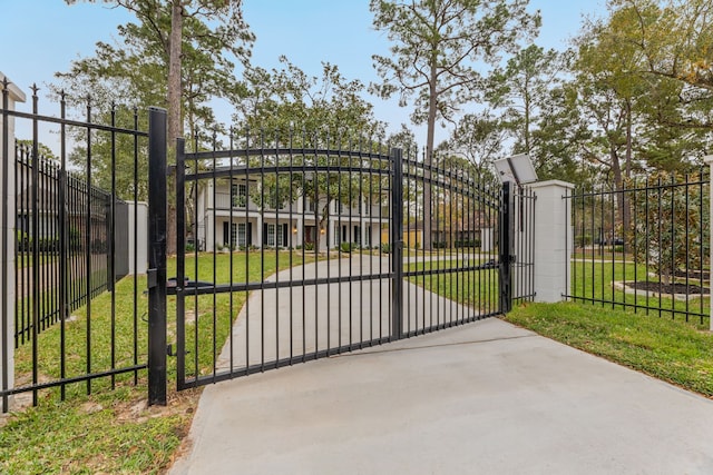 view of gate with a yard