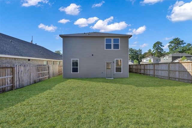 rear view of house featuring a yard