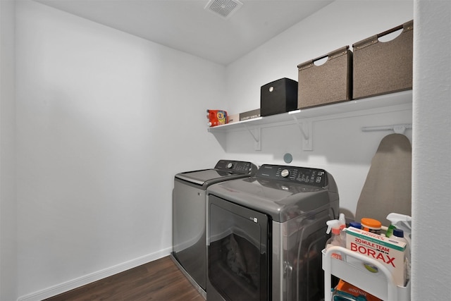 clothes washing area featuring washer and dryer and dark wood-type flooring