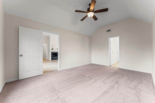 empty room with ceiling fan, light carpet, and vaulted ceiling