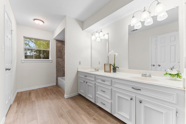 bathroom featuring hardwood / wood-style floors, vanity, and tiled shower / bath