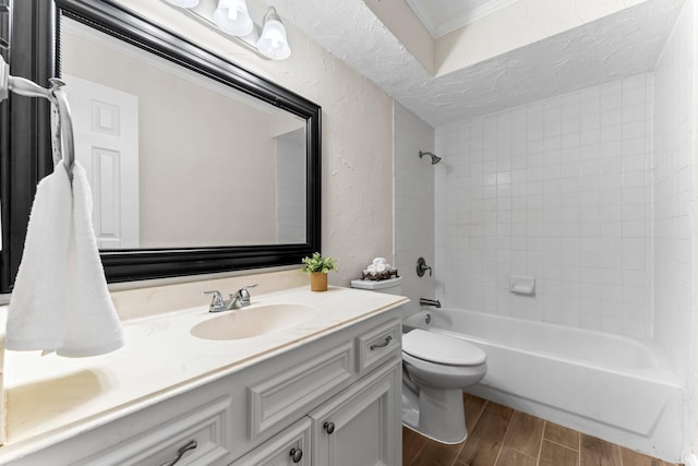 full bathroom with vanity, crown molding, hardwood / wood-style flooring, toilet, and tiled shower / bath