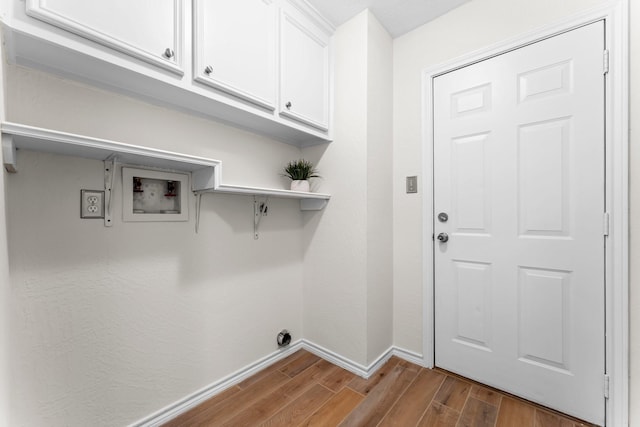 laundry room featuring cabinets, hardwood / wood-style floors, and washer hookup