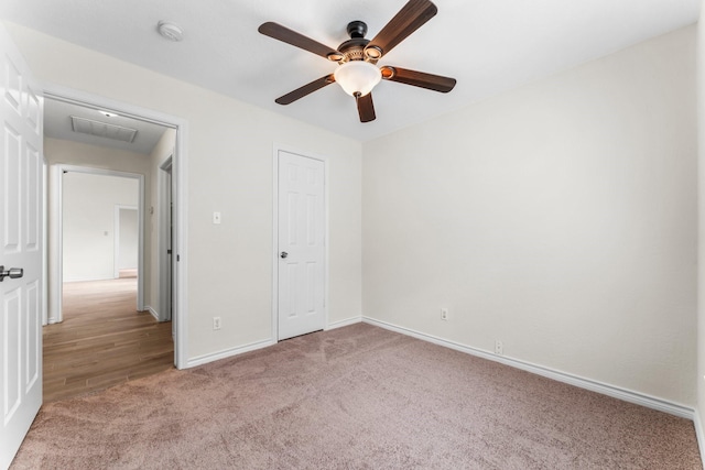 unfurnished bedroom with ceiling fan, light colored carpet, and a closet