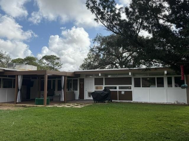 rear view of property with a yard