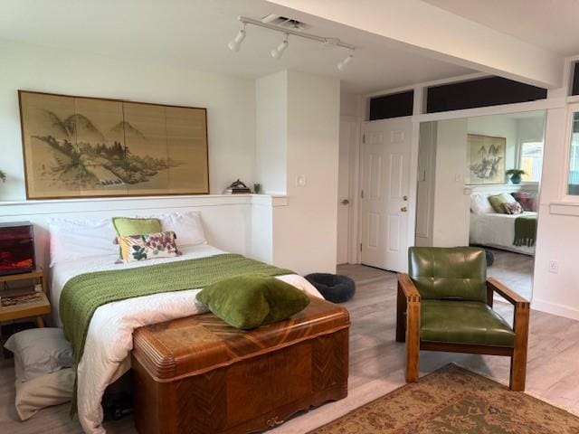 bedroom with wood-type flooring and rail lighting