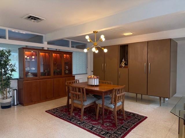 dining space featuring beamed ceiling and a notable chandelier