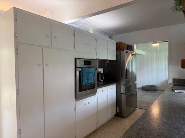 kitchen with white cabinets, light wood-type flooring, and appliances with stainless steel finishes