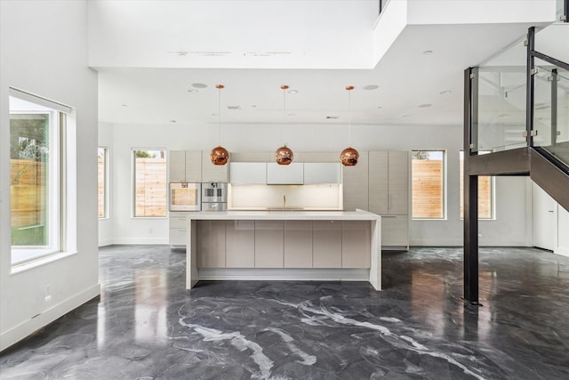 kitchen featuring stainless steel double oven, decorative light fixtures, a spacious island, and a breakfast bar area