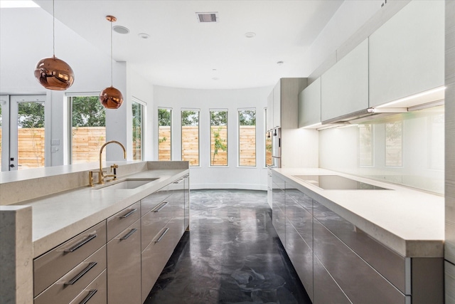 kitchen featuring sink, hanging light fixtures, and black electric stovetop